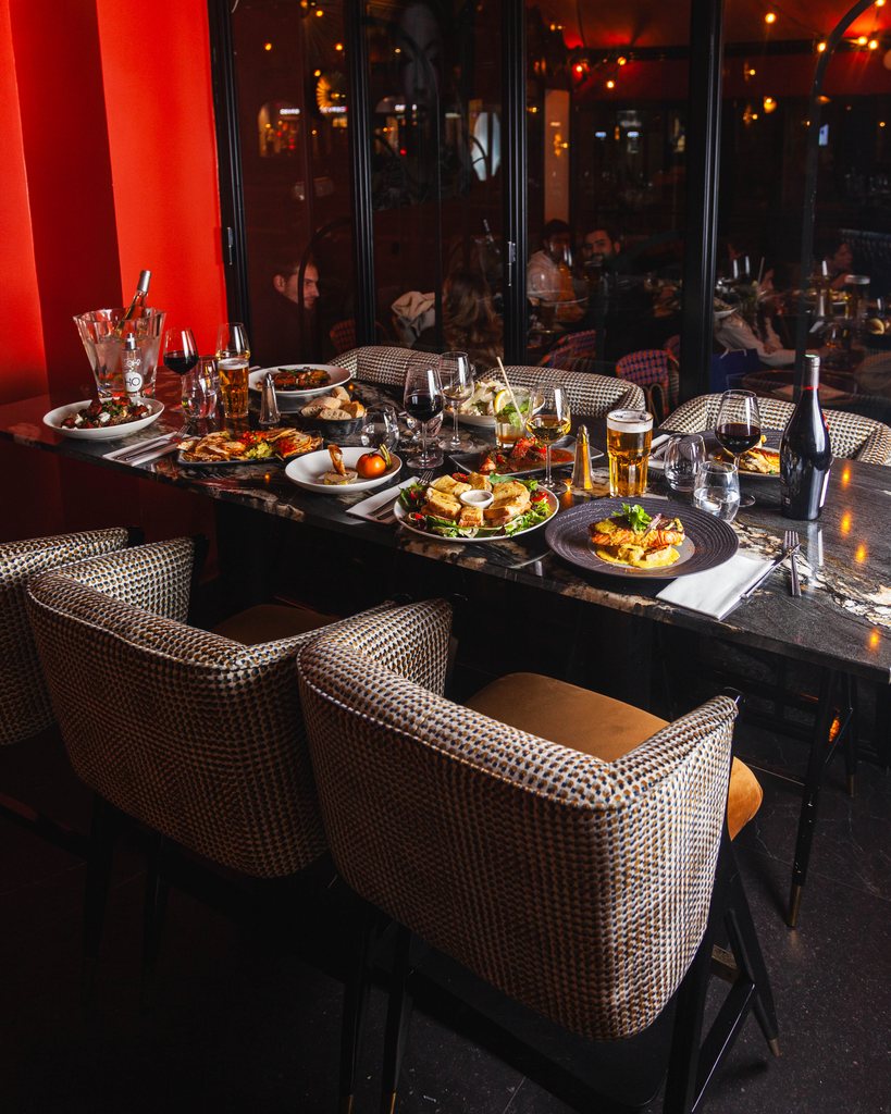 Grande table dressée aux Pipelettes du Boulevard, plats à partager face au boulevard