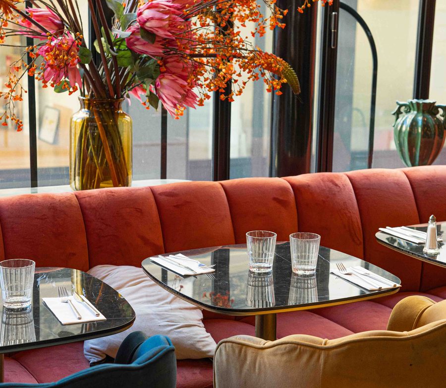 La salle des Pipelettes du Boulevard, banquettes corail et bouquet de saison