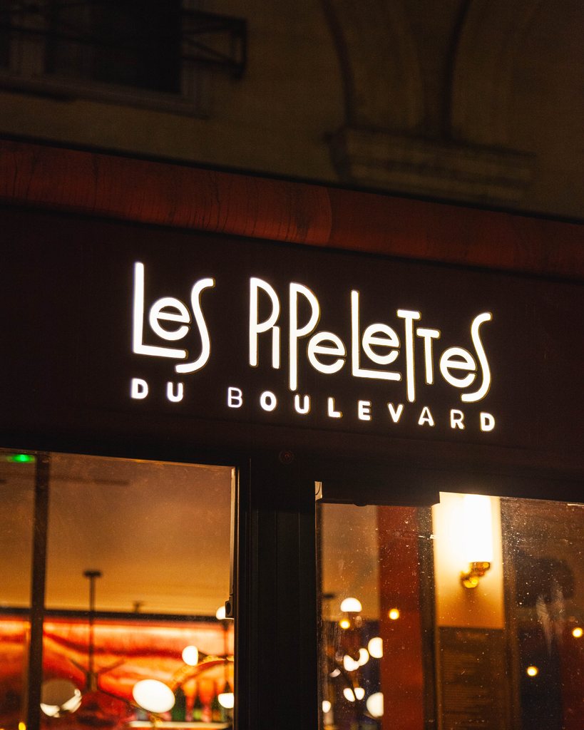 L’enseigne au néon des Pipelettes du Boulevard, à la nuit tombée